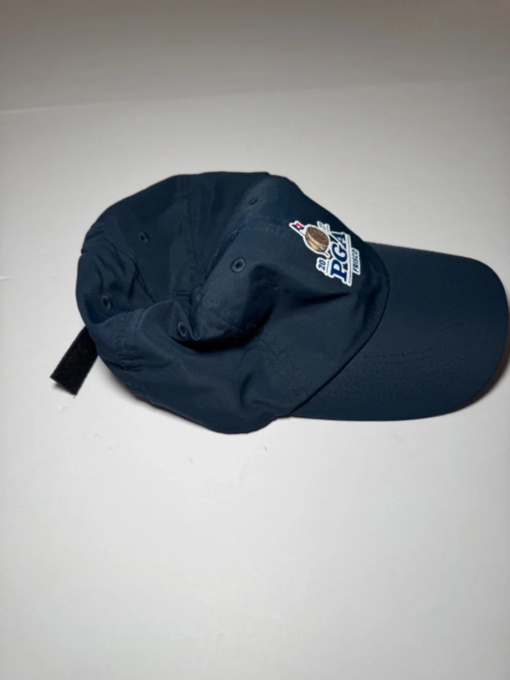 Description: Imperial golf cap in navy blue featuring an embroidered 2027 PGA Fr